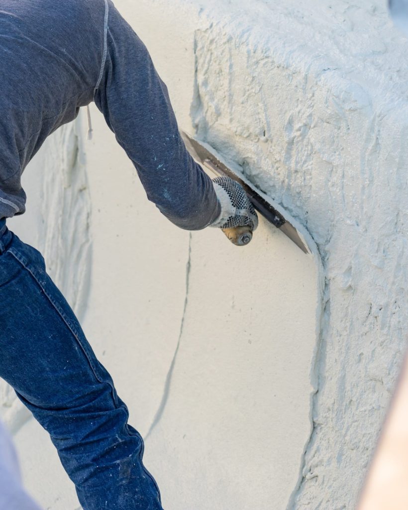 Worker Smoothing Wet Pool Plaster With Trowel